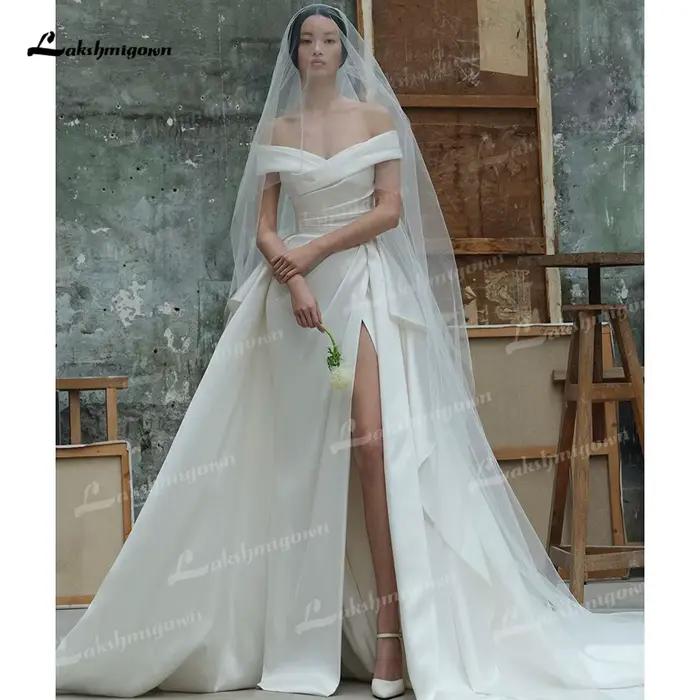 Robe de mariée moderne en satin drapée, coupe évasée, épaules dénudées, fente haute, traîne détachab