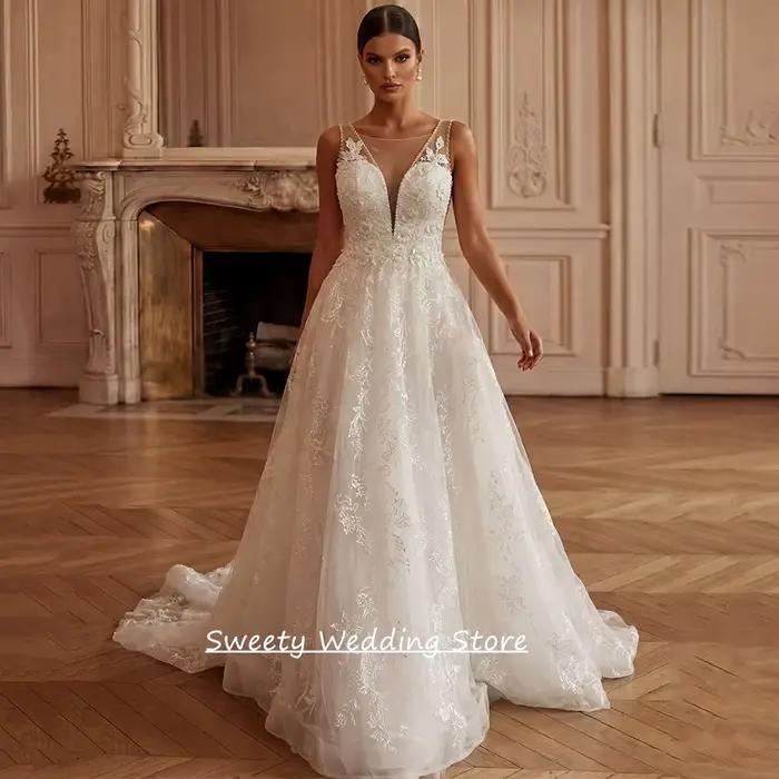 Robe de mariée charmante personnalisée sans manches, col en V profond, ornée de perles et de dentell