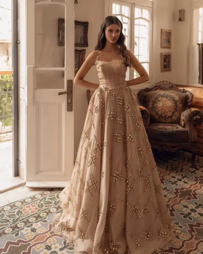 L'une robe de mariée personnalisée FATAPAESE comprend une jupe volumineuse en tombe de champagne déc
