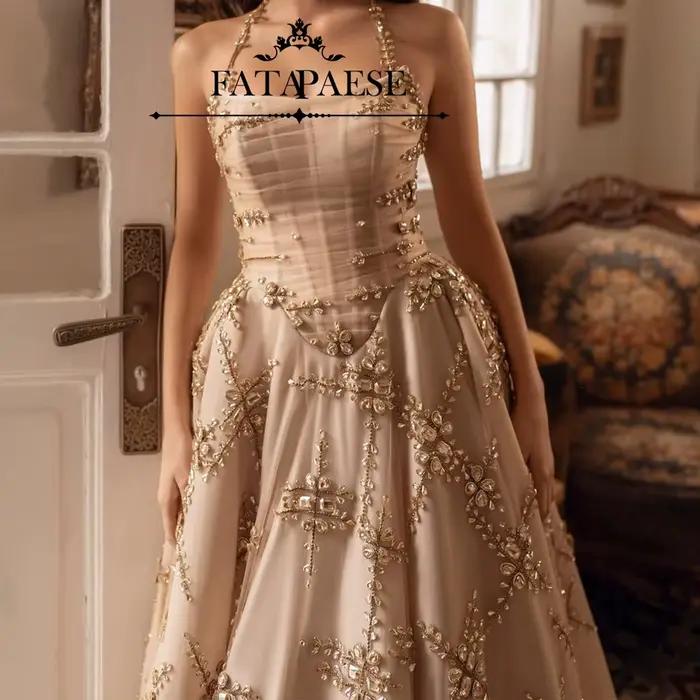 L'une robe de mariée personnalisée FATAPAESE comprend une jupe volumineuse en tombe de champagne décennement ornée de cristaux dispersés étincelles