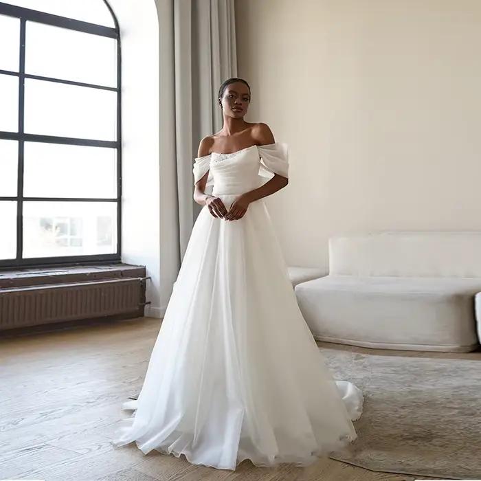 Robe de mariée élégante en tulle à épaules dénudées, corsage drapé, coupe trapèze, traîne chapelle,
